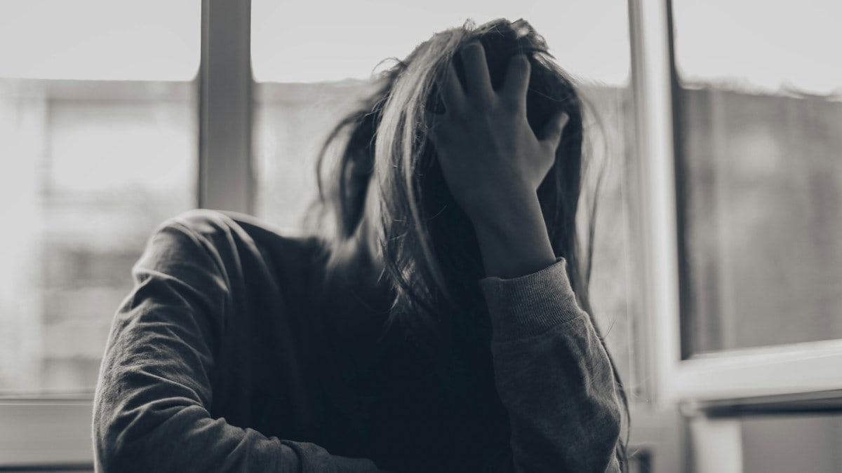 grayscale photography of person covering face